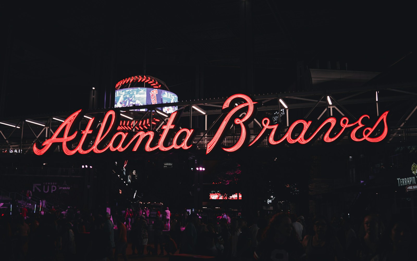 a crowd of people standing around a neon sign